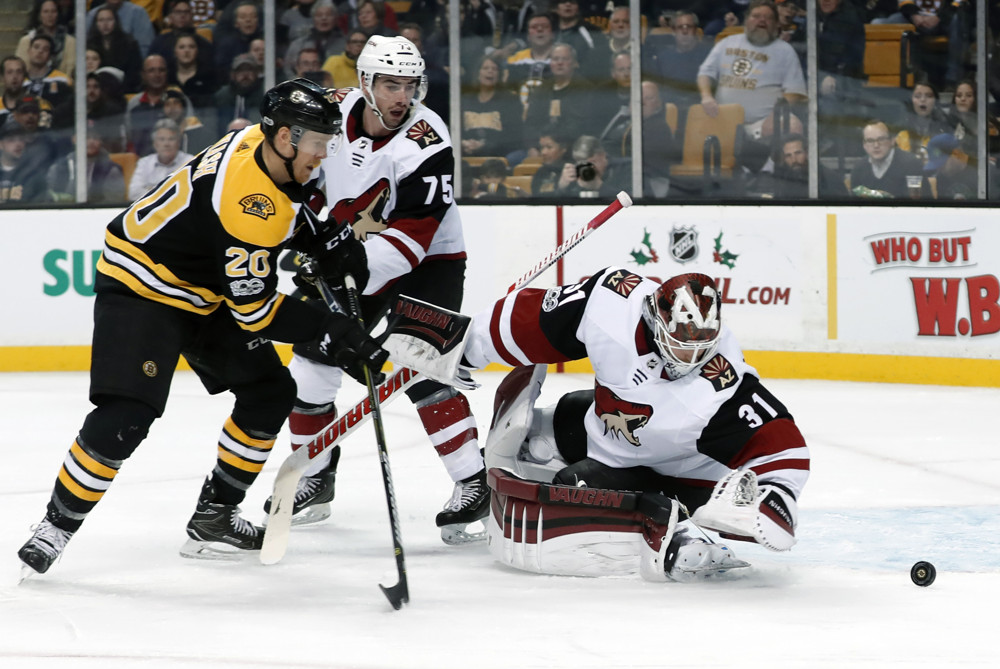 BOSTON, MA - DECEMBER 07: Arizona Coyotes defenseman Kyle Capobianco (75) tries to stop Boston Bruins center Riley Nash (20) as Arizona Coyotes goalie Scott Wedgewood (31) reaches for the loose puck during a game between the Boston Bruins and the Phoenix Coyotes on December 7, 2017, at TD Garden in Boston, Massachusetts. The Bruins defeated the Coyotes 6-1. (Photo by Fred Kfoury III/Icon Sportswire)